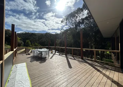 Wide hardwood deck with timber posts and wire balustrade overlooking bushland