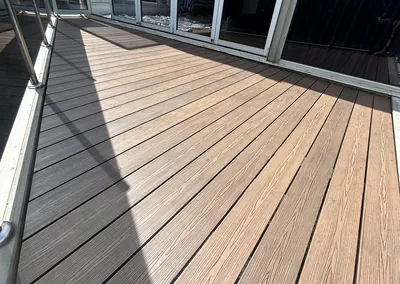 Freshly oiled hardwood deck boards leading to sliding glass doors