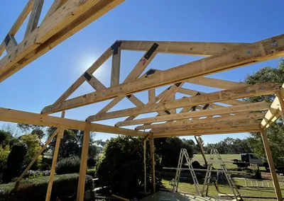 Timber pergola roof structure going up over a backyard